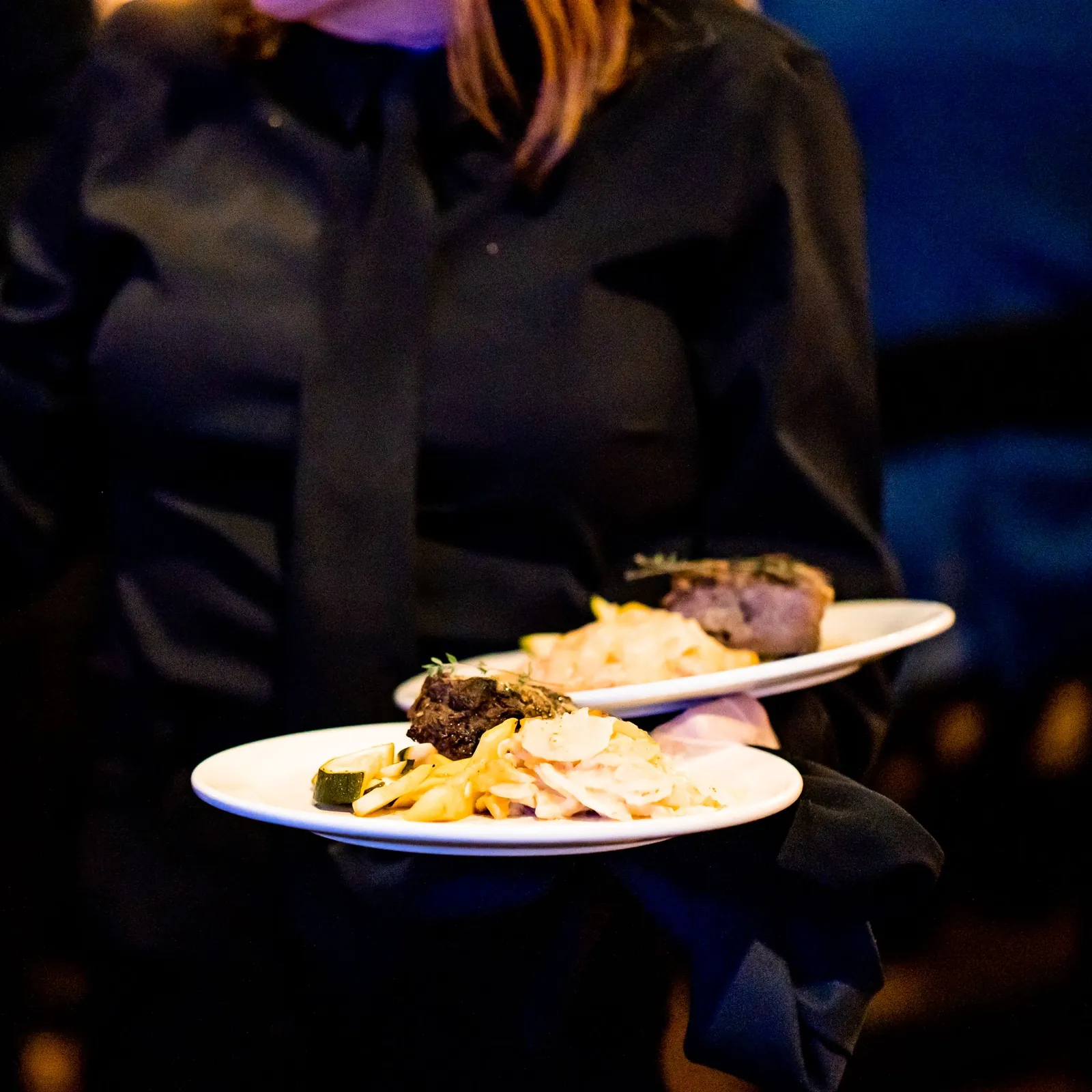 A server carrying plated courses through an event